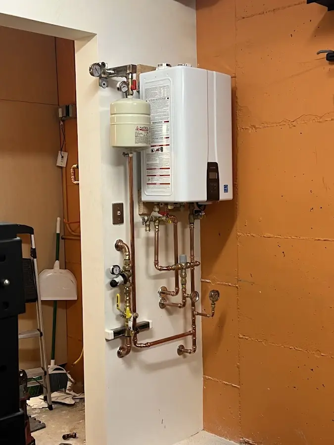 Plumbing technician inspecting water heater connections in Vevay